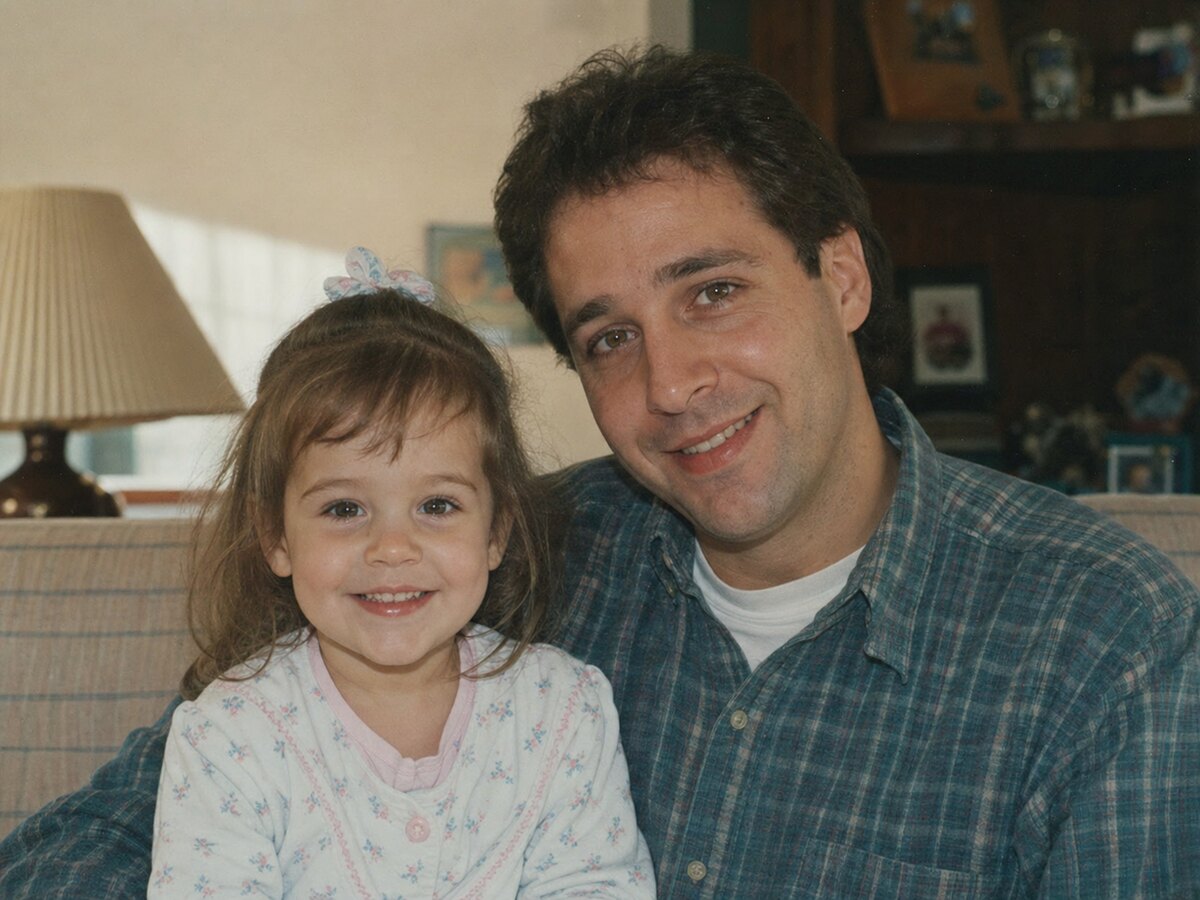 A scanned 1990s family photo of three-year-old Emma with her father Marcus