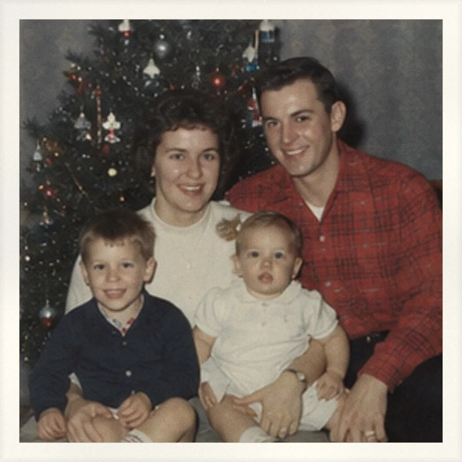 A family of four in front of a Christmas tree, with no date printed anywhere on the photo.