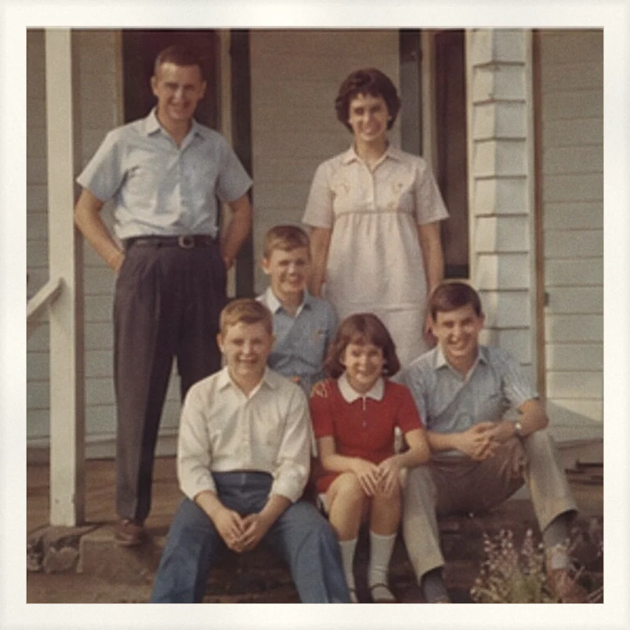 A family and their cousins posed on a front porch, with no date printed anywhere on the photo.