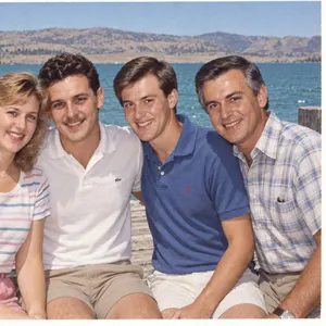 A scanned 1984 photo of four people on a lake dock, full screen on a TV