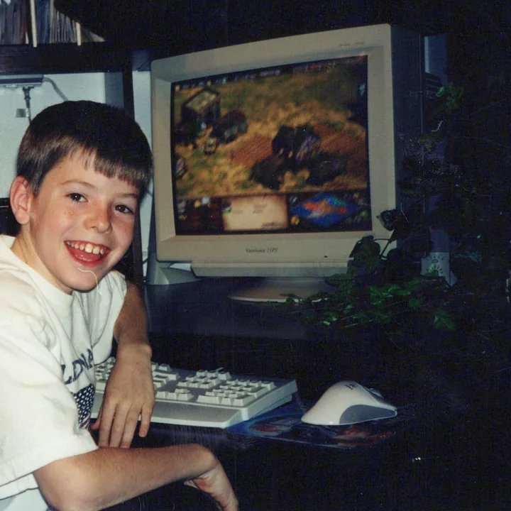 A boy smiling at a computer