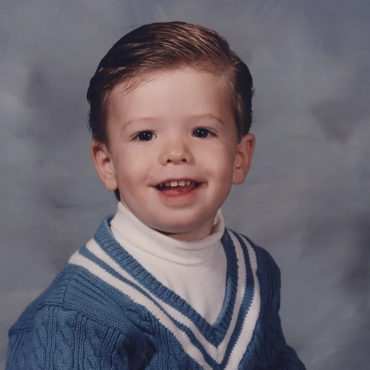 A school portrait of a toddler in a sweater