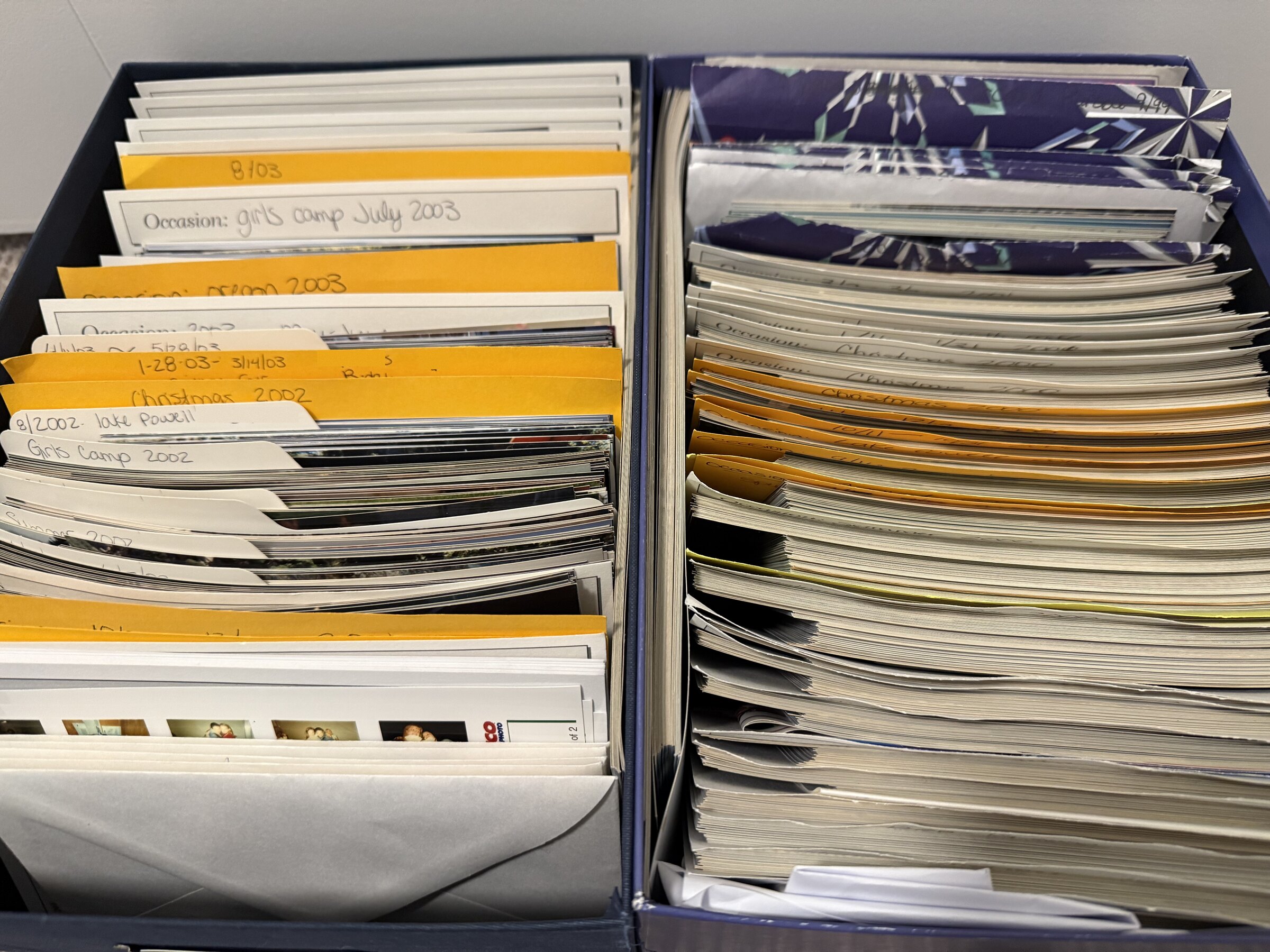 Photo envelopes labeled by hand with dates and occasions like Christmas 2002 and girls camp July 2003.